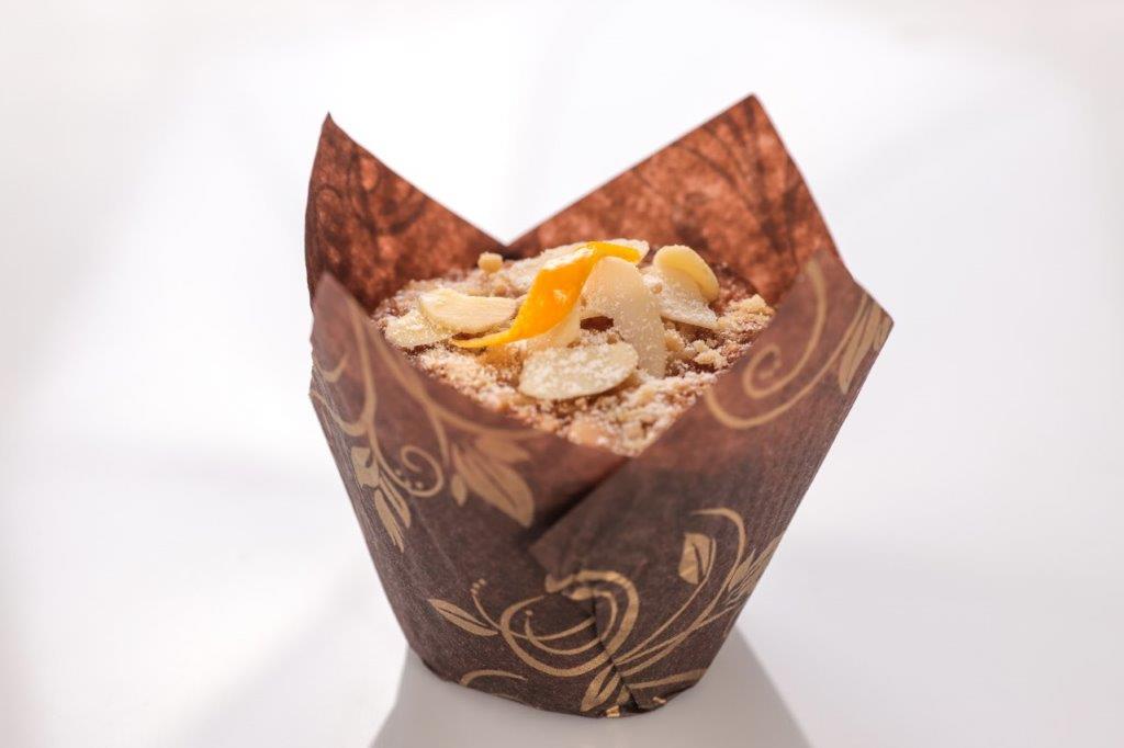 Forma de tulipán marrón con flores doradas que contiene un muffin con almendras